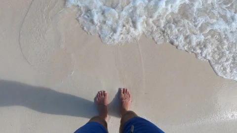 Waves lapping over mans feet Stock Footage 146463174