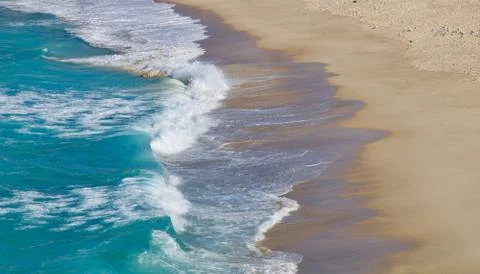 Waves lapping onto a sandy beach - image Stock Photos