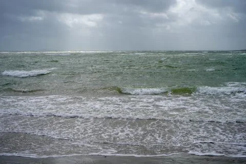 Waves lapping on a sandy beach shore 库存照片