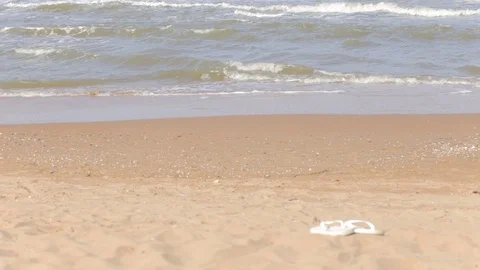 Waves lapping on a sandy shore, no people, beach Slippers on the beach Stock Footage 97259500