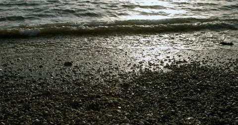 Waves lapping on the shore with sunest, sunlight Stock Footage 125497825