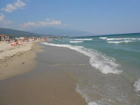 Waves on a long sandy beach Stock Photos