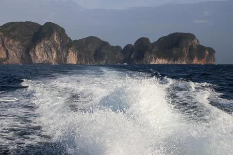 Waves made by a boat leaving Phi Phi Island with island in the background Stock-Fotos