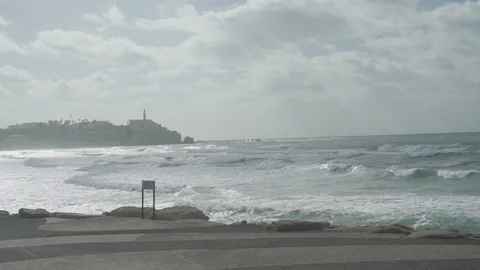 Waves move in slow motion with old city in background Stock Footage 100705119