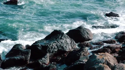 Waves of the ocean are breaking against the rocks  Stock Footage 84005650