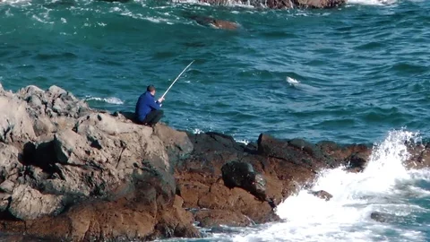 Waves of the ocean are breaking against the rocks  Stock Footage 84005682