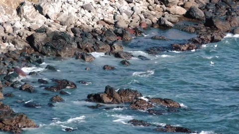 Waves of the ocean are breaking against the rocks  Stock Footage 84005731