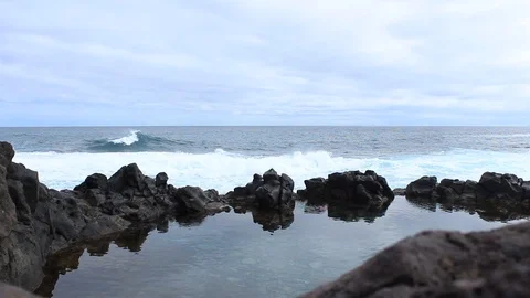 The waves of the ocean break on the rocks Stock Footage 98564013