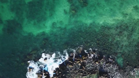 The waves of the ocean break on the rocky shore. Transparent clean water Stock Footage 185372586