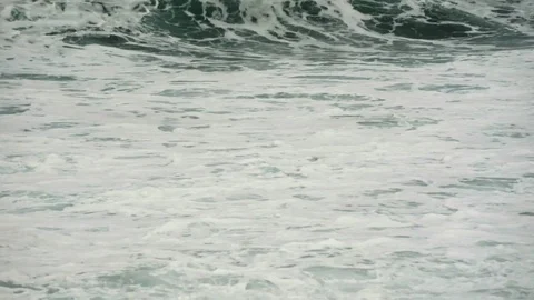 Waves of the ocean breaking in foam against the coast Stock Footage 80139448