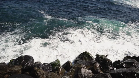 The waves of the ocean crash against the rocks and stones of the coast. Stock Footage 145276936