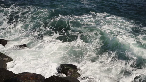 The waves of the ocean crash against the rocks and stones of the coast. Stock Footage 145277281