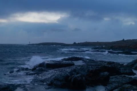 Waves from ocean hitting rocks with clouds Stock Photos