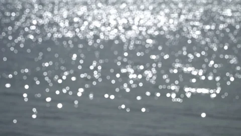 The waves of the ocean reflecting in the sunlight with a bokeh (blurry) Stock Footage 117675567