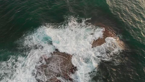 The waves of the ocean roll over the stone in the water Stock Footage 148335650