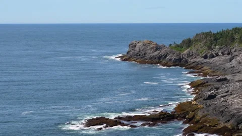 Waves from the ocean rolling in towards the rocky shoreline on the Maine coast. Stock Footage 323873034