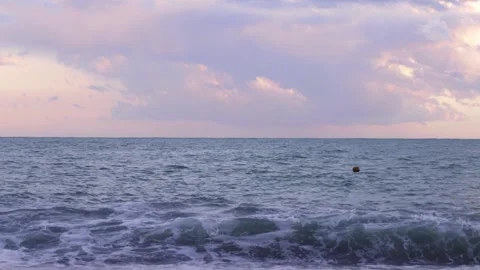 Waves on the ocean at sunset against a purple sky Stock Footage 211012443