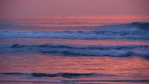 The waves of the ocean at sunset in a pink light Stock Footage 130256530