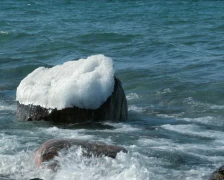 Waves over Ice Capped Boulder PAL Stock Footage 10824621