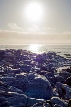 Waves over white sunset rocks Stock Photos