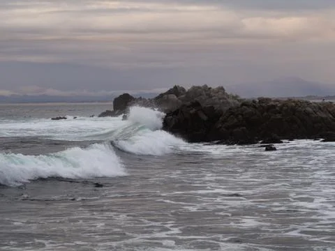 Waves of the Pacific Ocean collide with the rocks of the coast in Monterrey.  Stock Photos