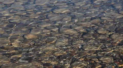 Waves pass over a rocky lake bottom Stock Footage 39634542
