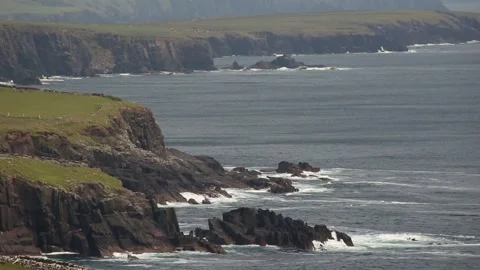 Waves pounding a jagged Atlantic coastline, wide view from the shore Stock Footage 230989155