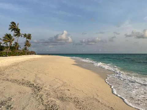 Waves racing onto the pristine white sand beach Stock Photos