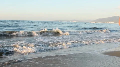 Waves reaching the beach shore with cinematic blue sea texture and clear sky, Stock Footage 327085153