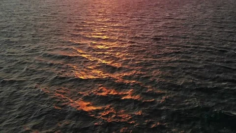 Waves refelcting and facing the sun in evening with islands in background Stock Footage 138075585