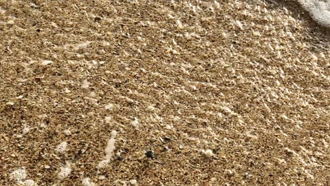 The waves retreating along the shore in slow motion. Stock Footage 307775607
