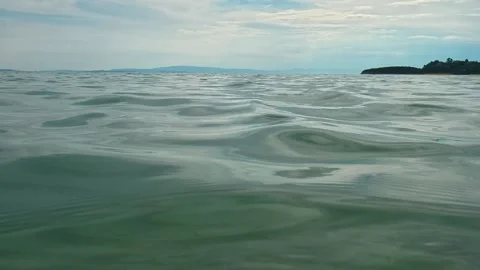 Waves ripple gently across calm, greenish-blue water. Trani Ammouda, Greece Stock Footage 339617840