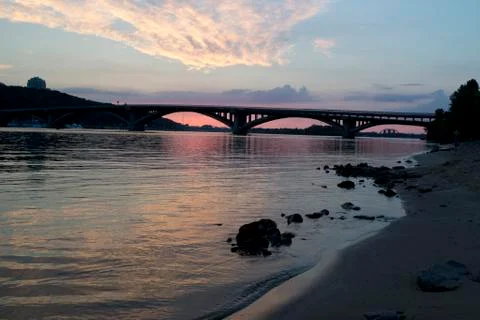 Waves on the river bank at sunset Stock Photos