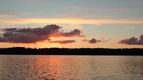 Waves on the river in the rays of sunset against the background of clouds. Stock Footage 202717408