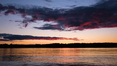 Waves on the river in the rays of sunset against the background of clouds. Stock Footage 202717641
