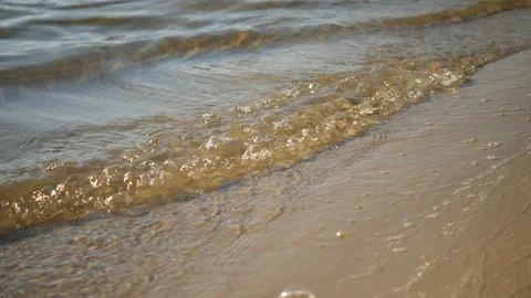 Waves of river rolling in sunshine to the sandy beach 스톡 동영상 221391478