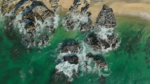 Waves on rocks jagged rocks on sandy beach Stock Footage 236742116