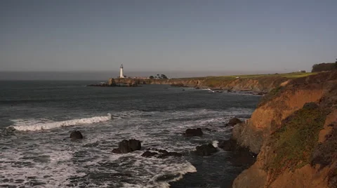 Waves on the rocks looking towards a lighthouse on Highway 1 in California Stock Footage 46940050
