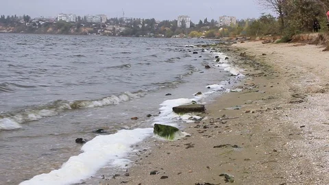 Waves roll on the bank of the river and beat stones with foam Vidéo 118744724