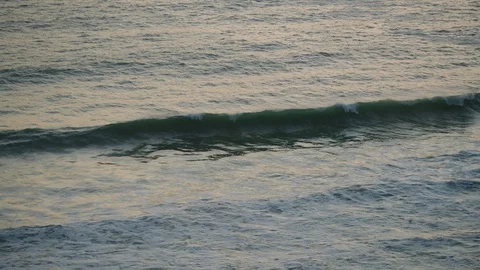 Waves roll into a bay at dusk in Cornwall, England. Stock Footage 128165860