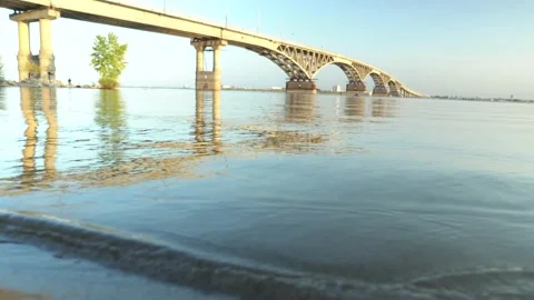 Waves roll on the beach against the background of the bridge Video stock 148104034