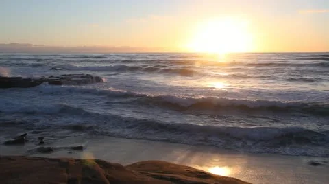 Waves roll in to a beautiful beach at Sunset Stock Footage 18136031
