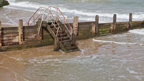 Waves roll in at high tide 스톡 동영상 251389627