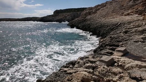 Waves roll with noise onto a rocky shore and beat against the shore. Beautiful Stock Footage 122096030