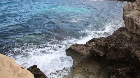 Waves roll with noise onto a rocky shore and beat against the shore. Beautiful Stock Footage 122096228