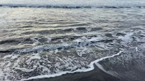 Waves roll in one after another. Black volcanic sand beach Video stock 141246939