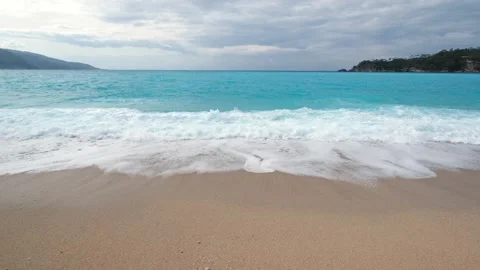 Waves roll over sandy beach 動画素材 304740552