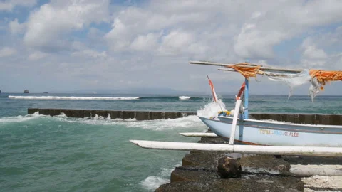 Waves roll on pier with catamaran under blue sky with clouds Video stock 102097888