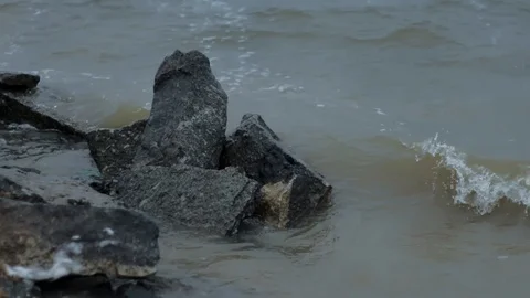 Waves roll on the sand and break on rocks Slow motion Stormy day Bad weather Stock Footage 96118799