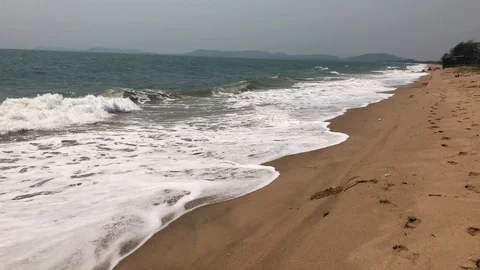 Waves roll onto a sandy beach Stock Footage 127875636
